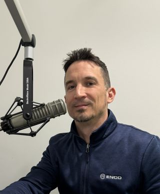 Ken Frommert of ENCO hosting a podcast in front of a hanging mic.